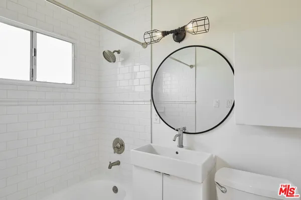 a bathroom with a sink a mirror and a shower