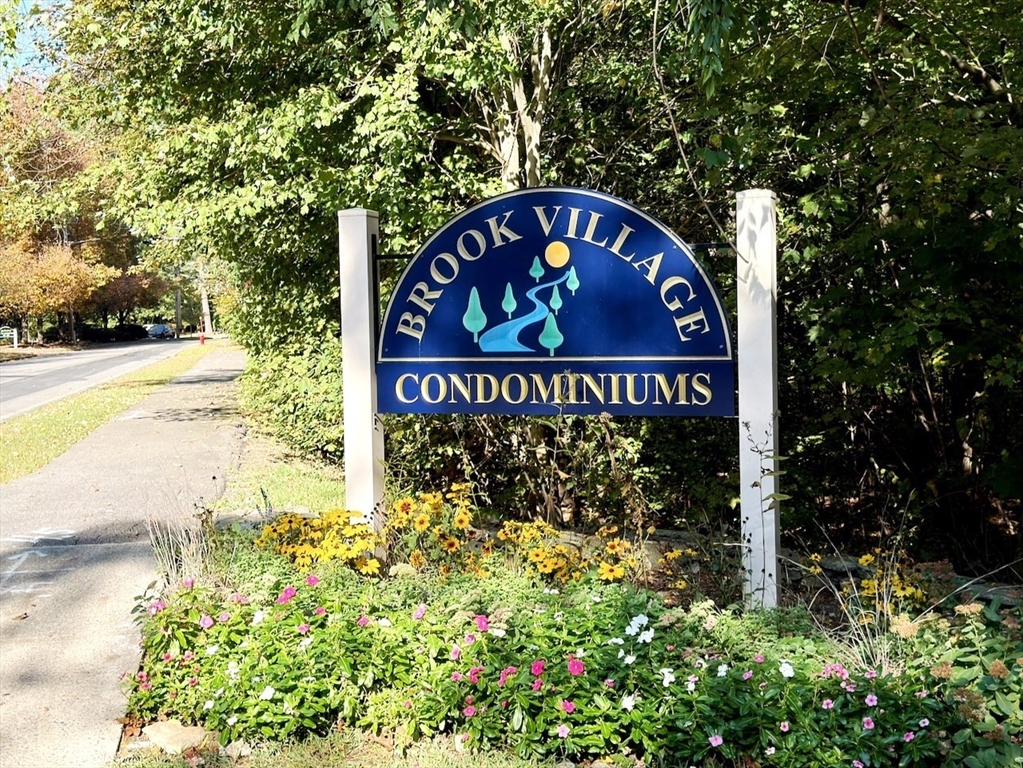 42 Swanson Court, Unit 14A Boxborough, MA 01719 - Photo 2 of 11 a sign broad in front of flowers