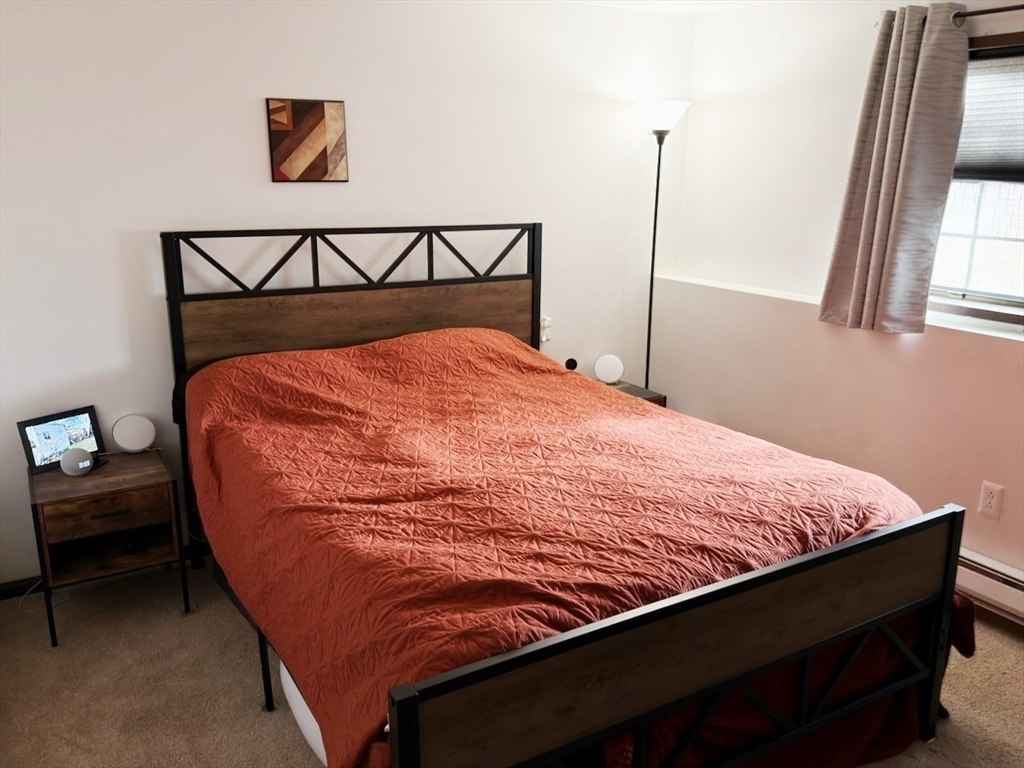 42 Swanson Court, Unit 14A Boxborough, MA 01719 - Photo 6 of 11 a bed sitting in a bedroom next to a window