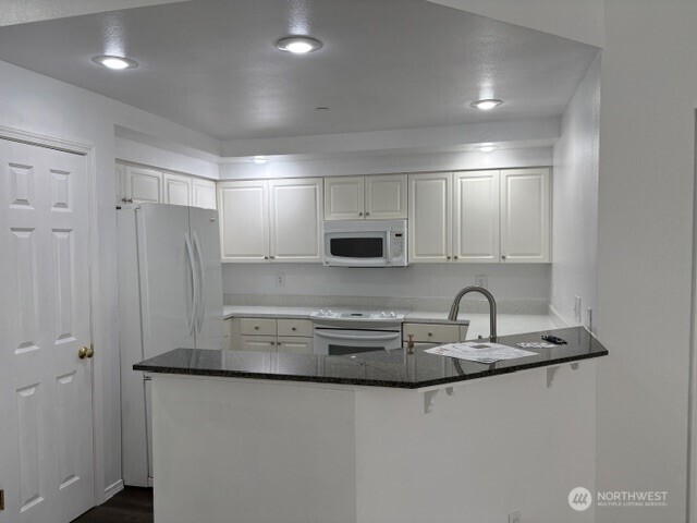 714 228th Street Southwest, Unit O101 Bothell, WA 98021 - Photo 10 of 28 a kitchen with stainless steel appliances a sink and cabinets