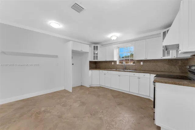 a kitchen with granite countertop a sink and cabinets