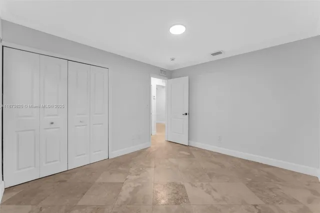 a bedroom with a large bed and a lamp