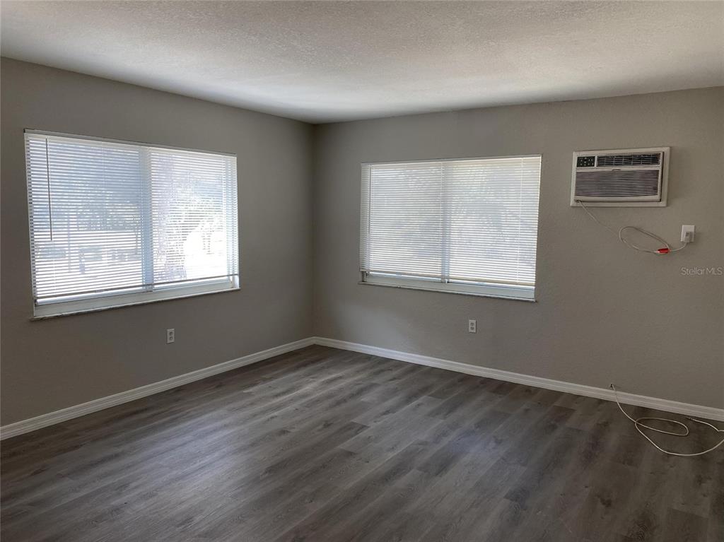 1090 Cocoanut Avenue, Unit 7 Sarasota, FL 34236 - Photo 3 of 7 a view of an empty room with wooden floor and a window