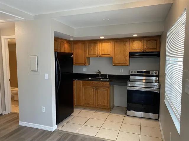 a kitchen with granite countertop a refrigerator and a sink
