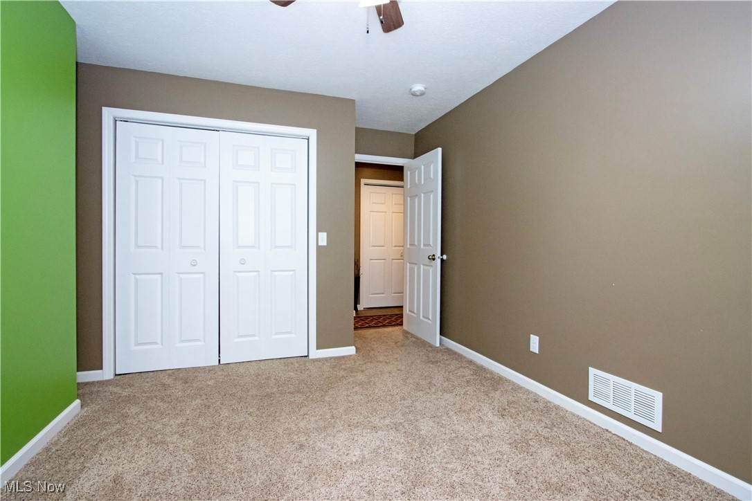 8249 Town Line Road Shiloh, OH 44878 - Photo 15 of 34 Unfurnished bedroom featuring carpet, a closet, and a ceiling fan
