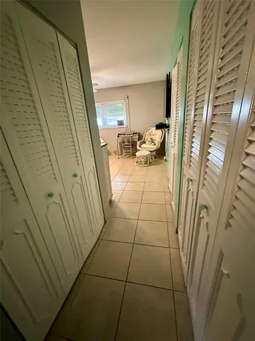 a bed room with a bed mirror and a flat tv screen on a dresser
