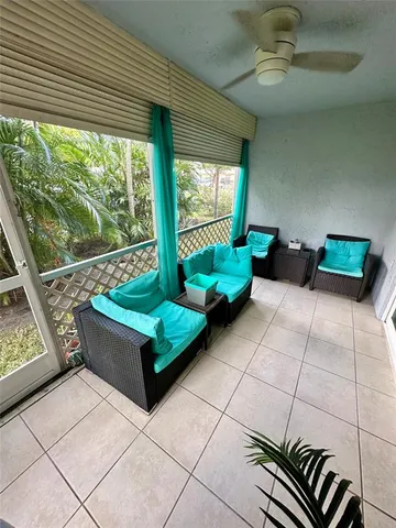a living room with patio furniture and a floor to ceiling window