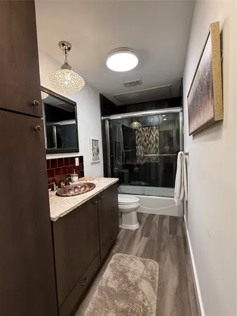 a view of a hallway with a dining table and chairs