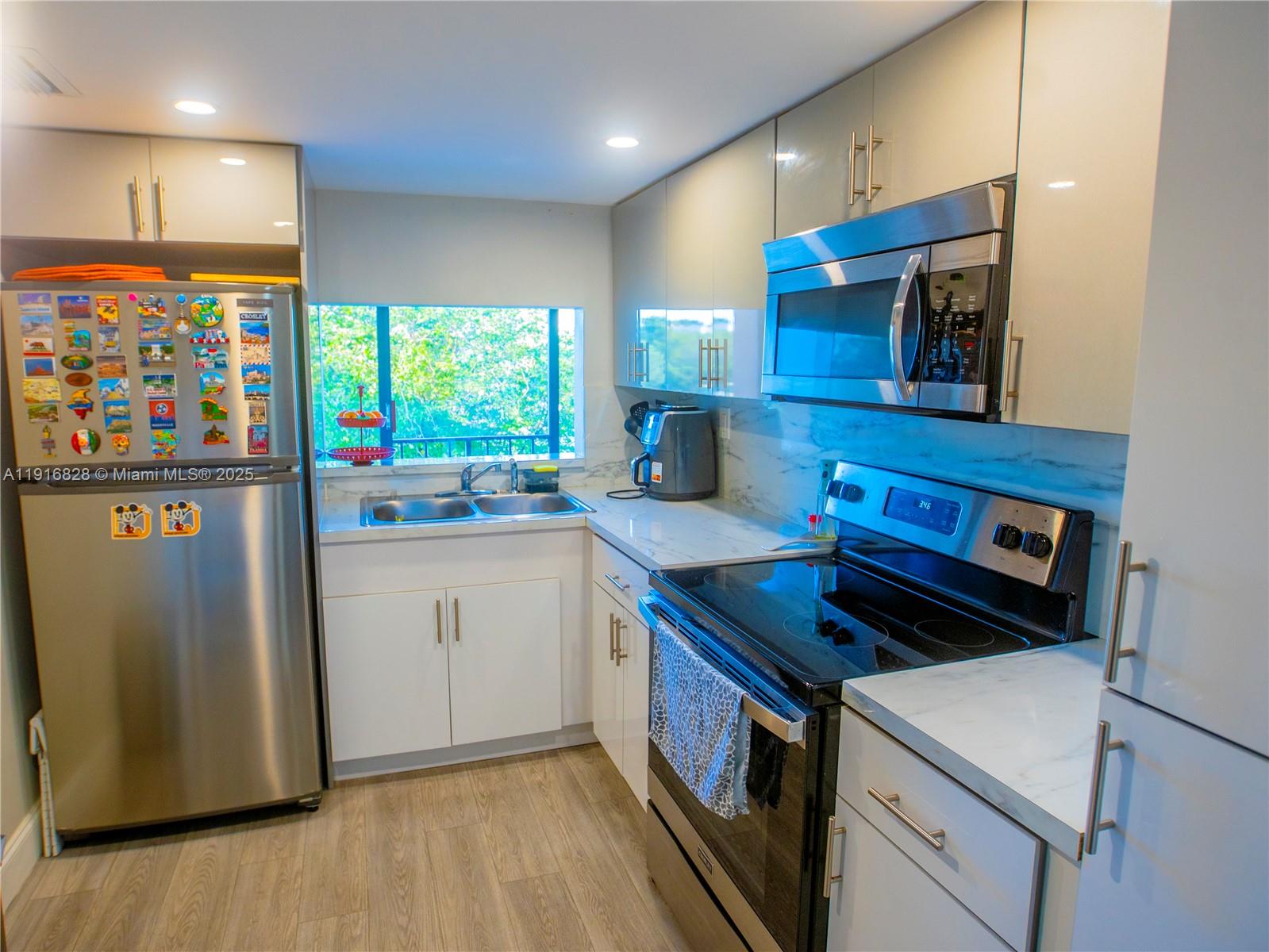 9400 West Flagler Street, Unit 313 Miami, FL 33174 - Photo 12 of 35 a kitchen that has a sink and a stove in it