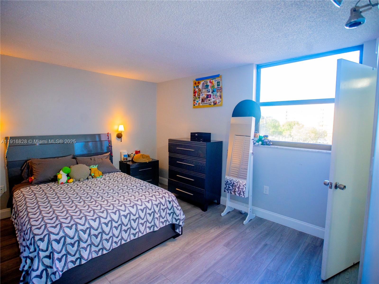 9400 West Flagler Street, Unit 313 Miami, FL 33174 - Photo 19 of 35 a bedroom with a bed and wooden floor