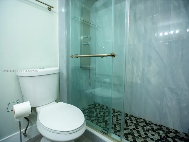 a bathroom with a toilet and a shower