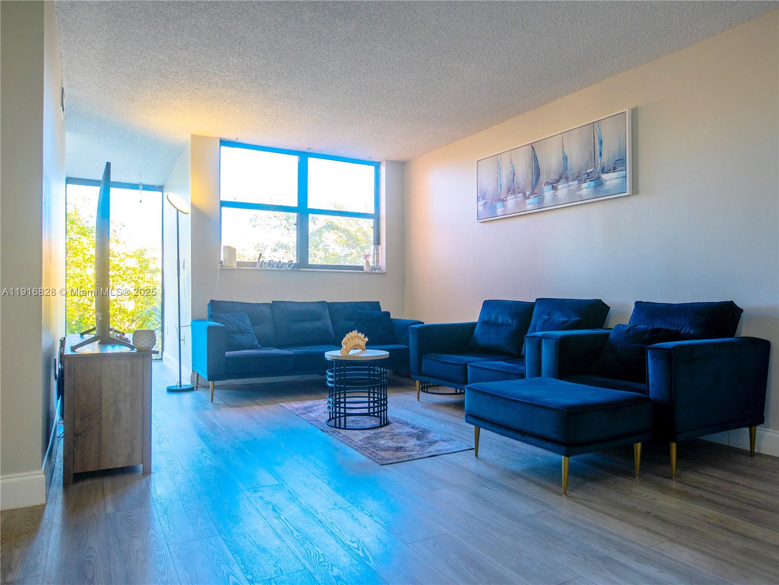 9400 West Flagler Street, Unit 313 Miami, FL 33174 - Photo 4 of 35 a living room with furniture and a wooden floor