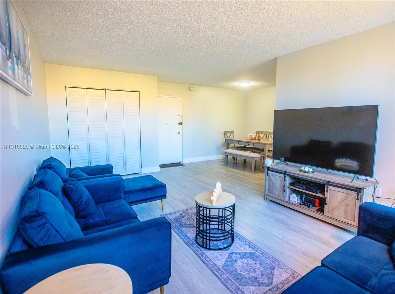 9400 West Flagler Street, Unit 313 Miami, FL 33174 - Photo 6 of 35 a living room with furniture and a flat screen tv