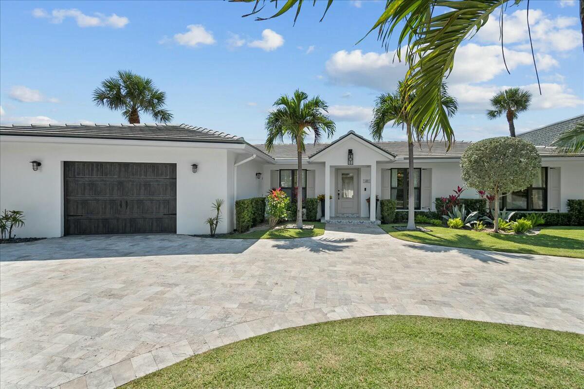 27 Ocean Drive Jupiter, FL 33469 - Photo 2 of 22 a front view of a house with a yard and garage