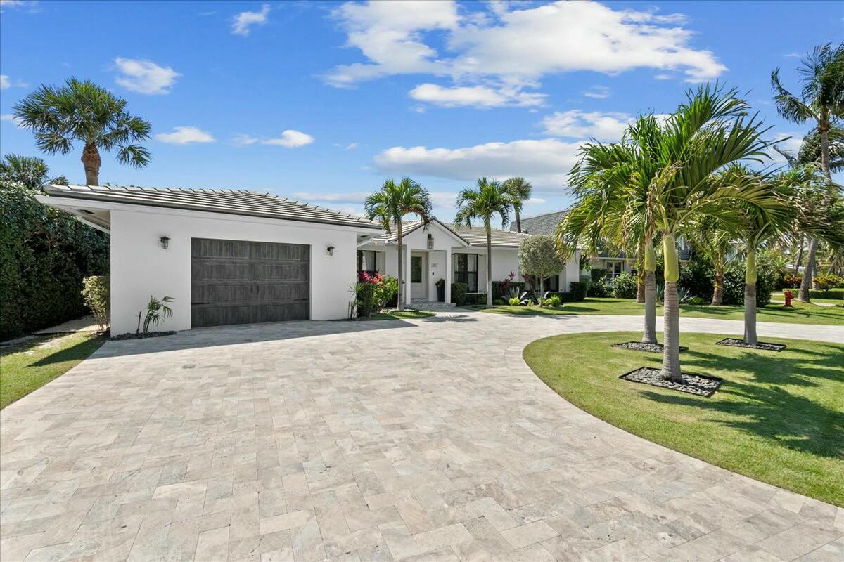 27 Ocean Drive Jupiter, FL 33469 - Photo 4 of 22 a front view of a house with a yard and palm trees