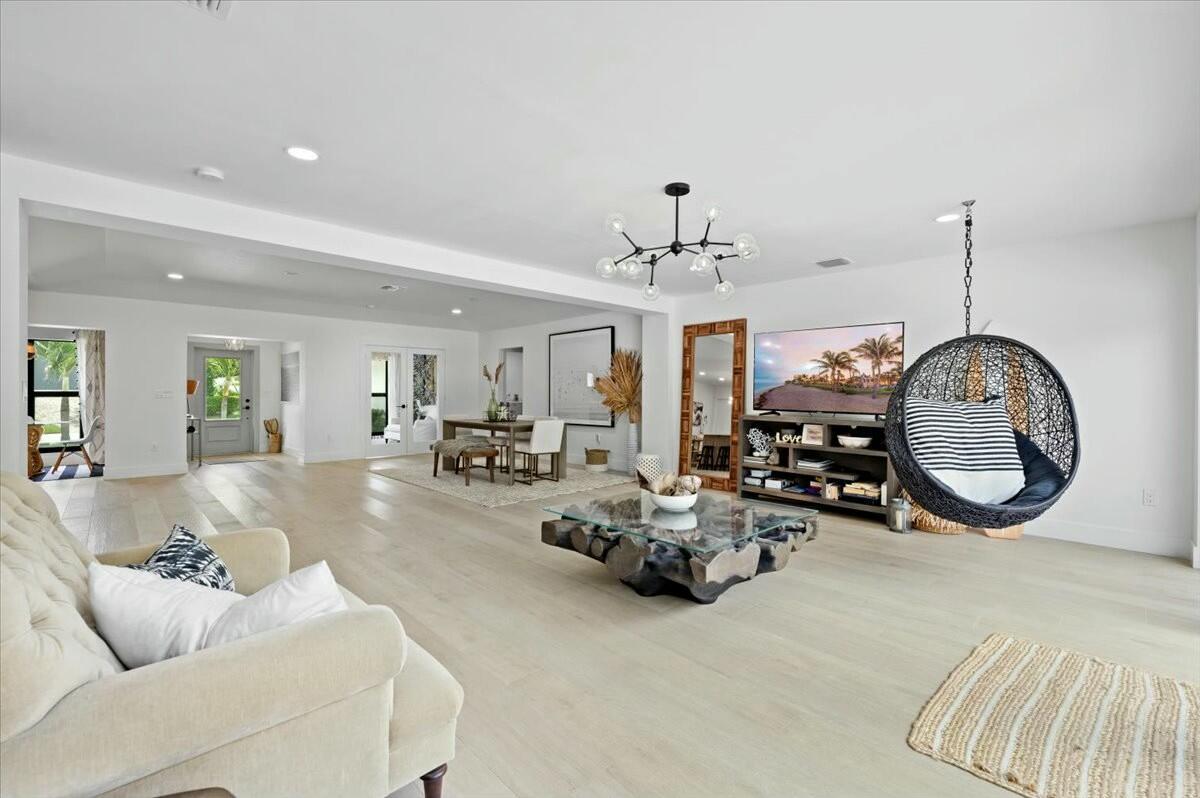 27 Ocean Drive Jupiter, FL 33469 - Photo 9 of 22 a living room with furniture a chandelier and a mirror