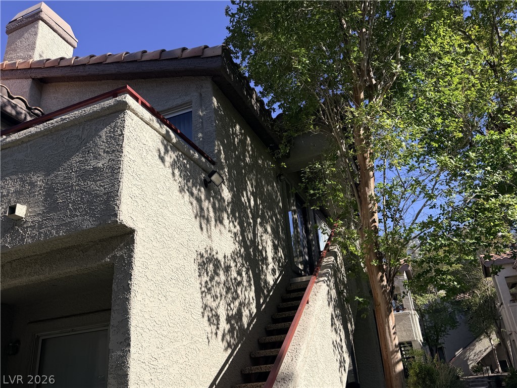 4955 South Lindell Road, Unit 203 Las Vegas, NV 89118 - Photo 30 of 31 A well-maintained stucco exterior complements the tiled roof and lush surrounding trees.