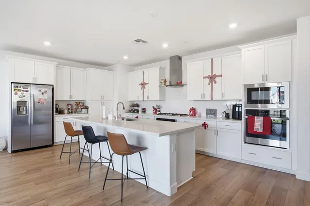 a kitchen that has a lot of cabinets a sink and appliances in it