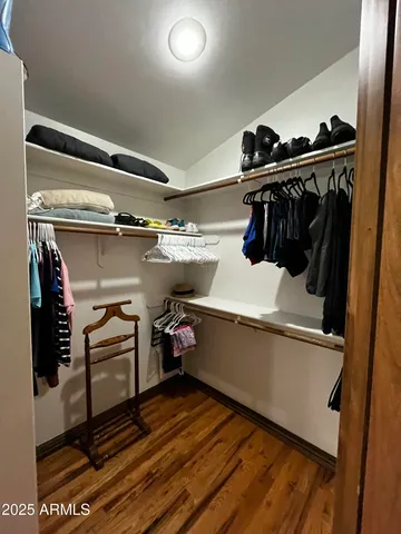 a view of walk in closet with clothes and shoes