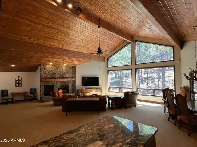 a living room with furniture large window and flat screen tv