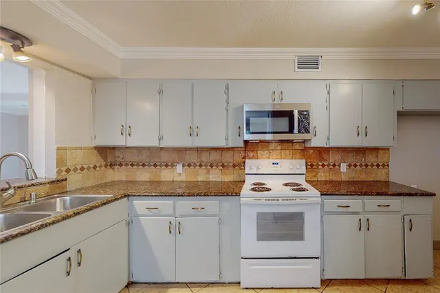 a kitchen with granite countertop white cabinets and white appliances