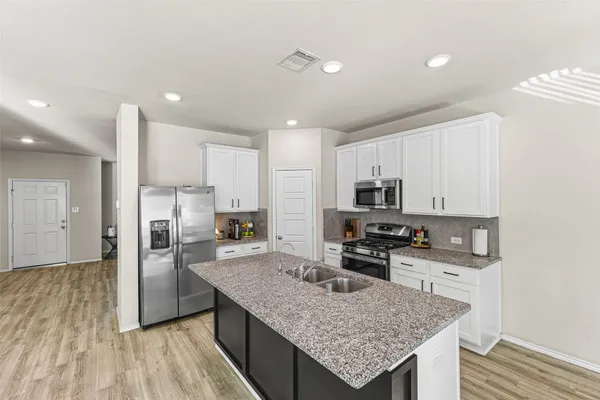 a kitchen with stainless steel appliances granite countertop a sink stove and refrigerator