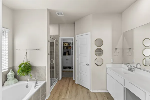 a bathroom with a tub sink and mirror