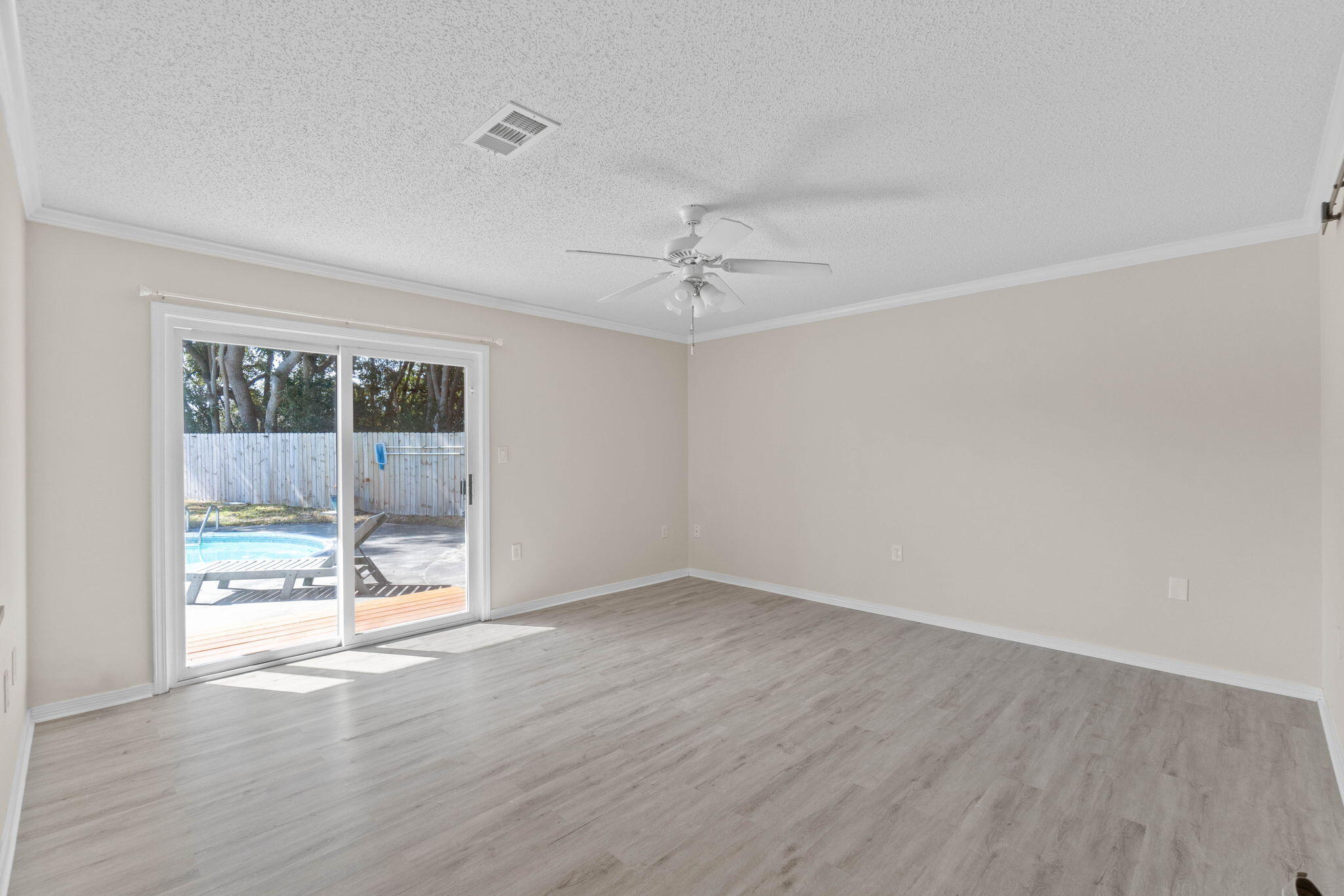54 Country Club Road Shalimar, FL 32579 - Photo 17 of 58 an empty room with wooden floor and a floor to ceiling window