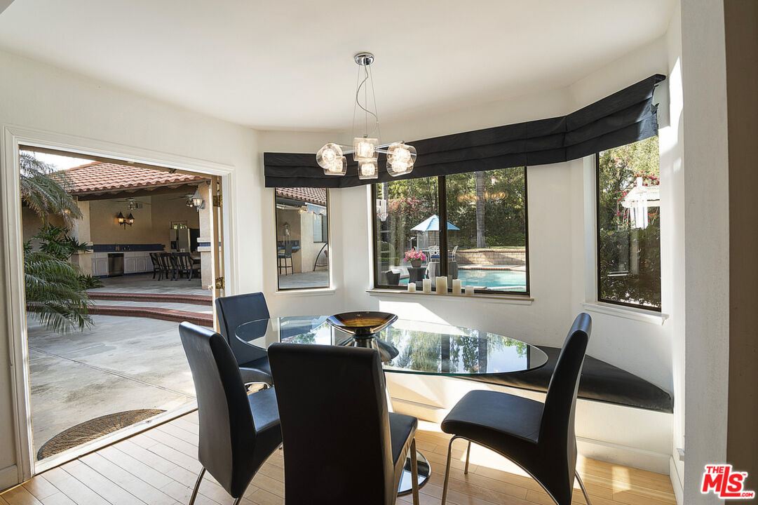 10560 Boulder Canyon Road Rancho Cucamonga, CA 91737 - Photo 12 of 30 a dining room with wooden floor a chandelier a glass table and chairs