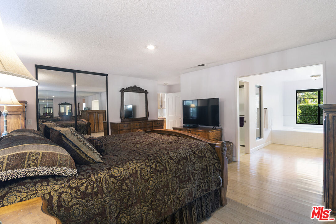 10560 Boulder Canyon Road Rancho Cucamonga, CA 91737 - Photo 16 of 30 a spacious bedroom with a bed and a flat screen tv