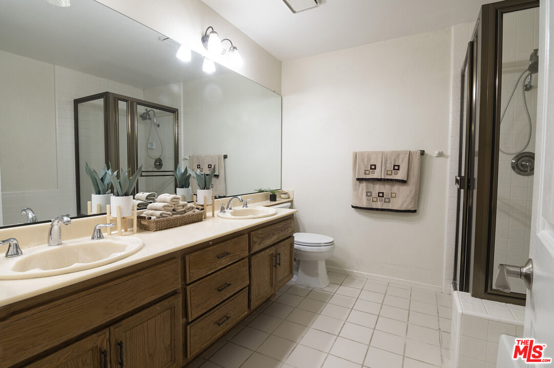 10560 Boulder Canyon Road Rancho Cucamonga, CA 91737 - Photo 20 of 30 a bathroom with a double vanity sink a mirror and a toilet