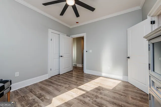 a bedroom with a large bed and a flat tv screen