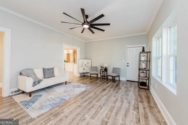 a living room with furniture and a wooden floor