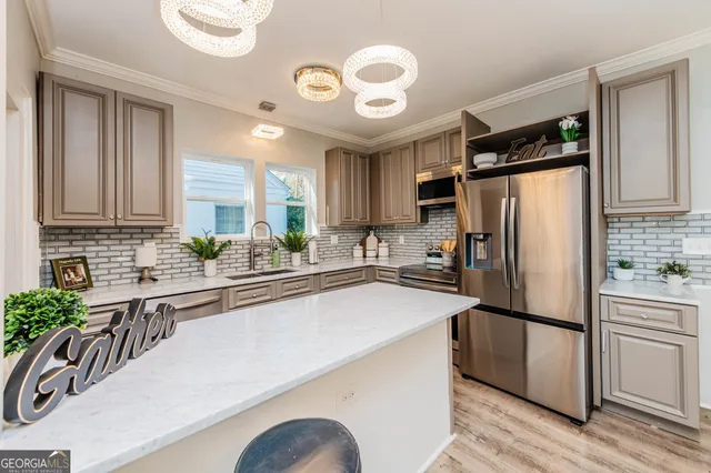a kitchen with stainless steel appliances a refrigerator sink and wooden floor