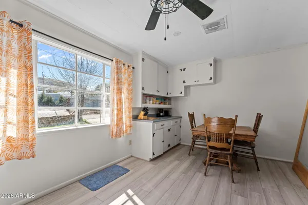 a kitchen with stainless steel appliances granite countertop a stove top oven a dining table and chairs with wooden floor