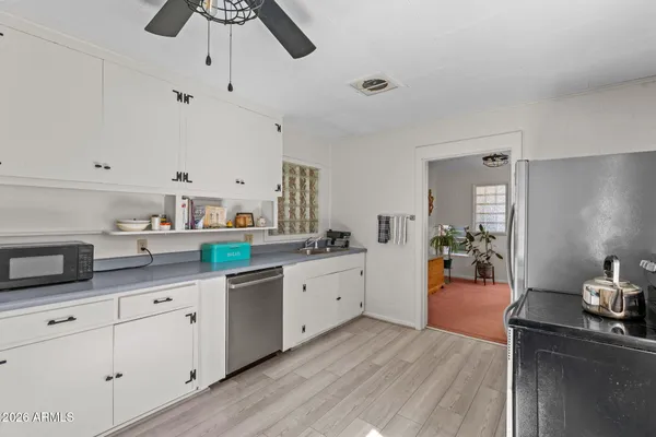 a kitchen with a sink cabinets and wooden floor