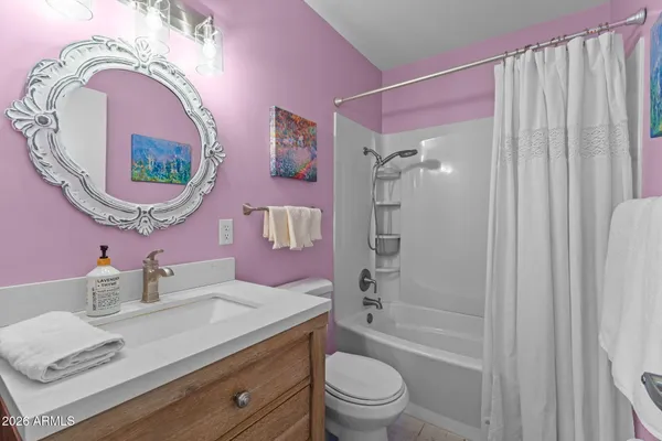 a bathroom with a granite countertop toilet a sink and a mirror