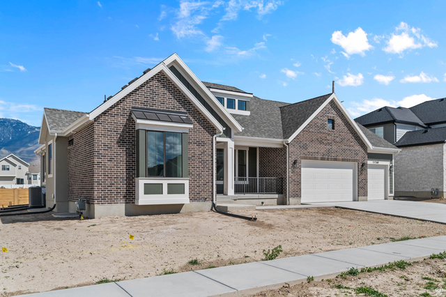 11749 South Halls Crk Road Draper, UT 84020 - Photo 2 of 21 View of front of home featuring brick siding, a porch, an attached garage, driveway, and a mountain view