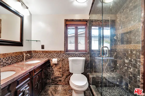 a bathroom with a toilet a sink and a mirror