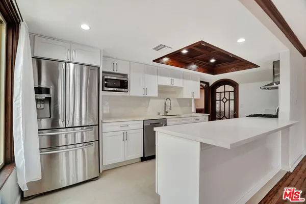 a kitchen with white cabinets and stainless steel appliances