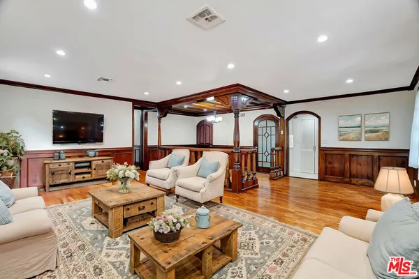 a living room with furniture ceiling fan and a flat screen tv