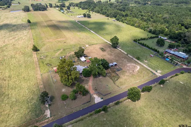 an aerial view of a house with a yard and lake view