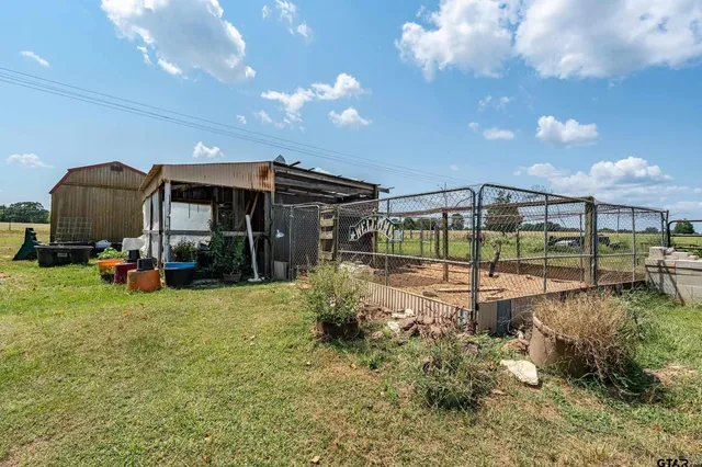 a view of backyard with table and chairs and potted plants