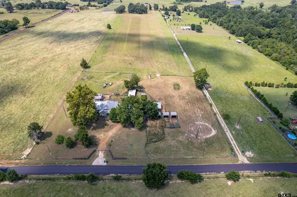 a view of a lake with couches and table and chairs under an umbrella