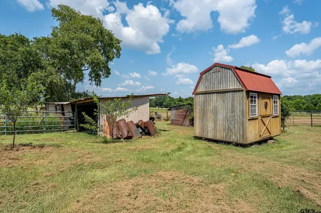 a backyard of a house with barbeque oven table and chairs