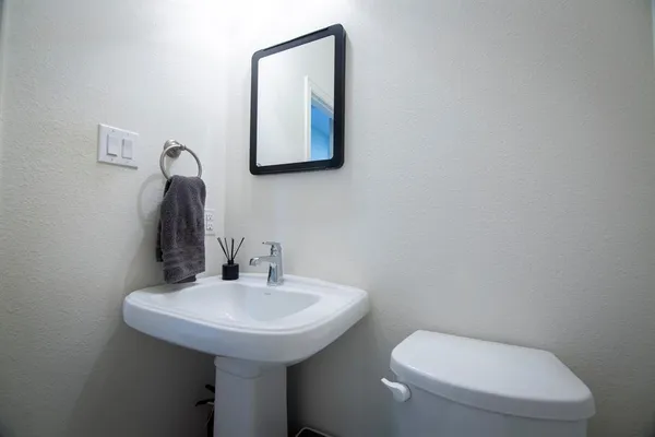 a bathroom with a toilet sink and mirror