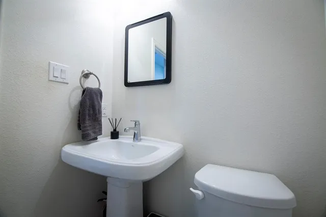 a bathroom with a toilet sink and mirror