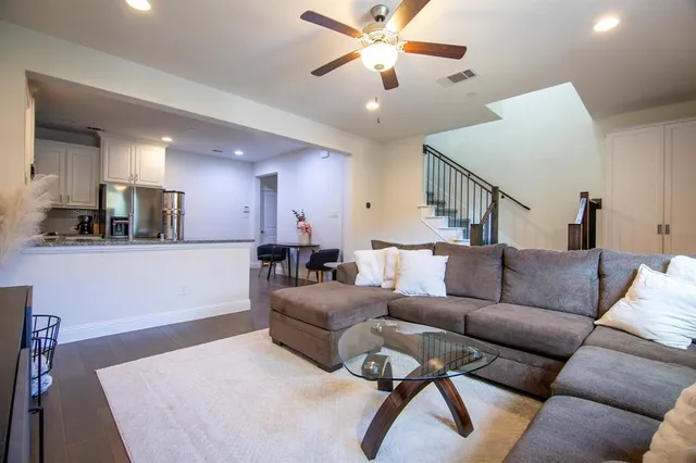 a living room with furniture and a view of kitchen