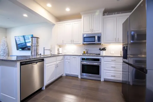 a kitchen with stainless steel appliances granite countertop a stove a sink and a refrigerator