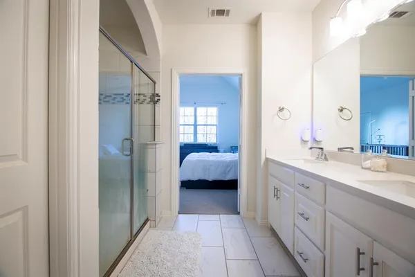 a en suite bathroom with a shower sink and mirror